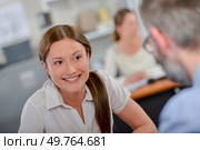 Smiling lady at desk opposite spectacled man. Стоковое фото, агентство Ingram Publishing / Фотобанк Лори