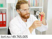 male scientist analysing something through a magnifying glass. Стоковое фото, агентство Ingram Publishing / Фотобанк Лори