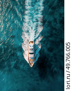 A white boat sails across the vast expanse of the ocean, surrounded by nothing but water.. White Boat in Middle of Ocean. Стоковое фото, агентство Ingram Publishing / Фотобанк Лори