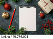 A notepad with a pencil surrounded by Christmas decorations like baubles, ribbons, and garlands.. Notepad With Pencil and Christmas Decorations. Стоковое фото, агентство Ingram Publishing / Фотобанк Лори