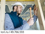 builder banging nail into wood with a hammer. Стоковое фото, агентство Ingram Publishing / Фотобанк Лори