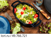 Broccoli casserole with prawns and cheese. Baked broccoli with scrimps in a ceramic form on rustic wooden table.. Baked gratin of broccoli and shrimps. Стоковое фото, агентство Ingram Publishing / Фотобанк Лори