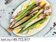 Plate with delicious smoked capelin. Smoked capelin fish with lemon. Стоковое фото, агентство Ingram Publishing / Фотобанк Лори