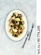 Snails baked with sauce, Bourgogne escargot snails, concept of french cuisine, gourmet food.. Baked snails with butter. Стоковое фото, агентство Ingram Publishing / Фотобанк Лори
