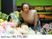A woman, full of enthusiasm, carefully selects an array of fresh, vibrant vegetables and ripe fruits inside a lively grocery store that is brimming with colorful and appealing produce options. A woman is shopping for fresh produce at a local grocery market filled with vibrant colors. Стоковое фото, агентство Ingram Publishing / Фотобанк Лори