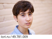 This closeup portrait showcases a young person with stylish short hair and a thoughtful expression, while the blurred background highlights their unique features and individuality. A Portrait of a Young Person with Short Hair Set Against a Soft and Gentle Background. Стоковое фото, агентство Ingram Publishing / Фотобанк Лори