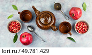 Delicious red tea and pomegranate on table in the teakettle.. Tea With Pomegranate Seeds. Стоковое фото, агентство Ingram Publishing / Фотобанк Лори