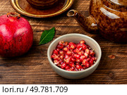 Aromatic berry tea, tea with fresh pomegranate seeds in the teakettle on rustic wooden table.. Tea with fresh pomegranate. Стоковое фото, агентство Ingram Publishing / Фотобанк Лори
