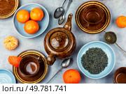 A porcelain tea set with tea mandarin or clementines. Top view.. Tea pot with clementines. Стоковое фото, агентство Ingram Publishing / Фотобанк Лори
