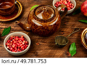 Delicious red tea and pomegranate on table in the teakettle. Food photography.. Tea With Pomegranate Seeds. Стоковое фото, агентство Ingram Publishing / Фотобанк Лори