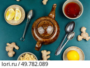 Ceramic teapot with fresh natural tea from fresh ginger root, honey and lemon, medicinal drink or tea. Top view.. Delicious ginger tea with lemon. Стоковое фото, агентство Ingram Publishing / Фотобанк Лори