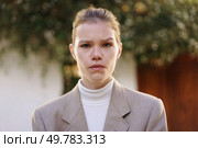 A poised young woman, confidently wearing a fashionable blazer coupled with a chic turtleneck, exudes an aura of selfassuredness while surrounded by a beautiful natural outdoor setting. A Confident Young Woman Dressed in Stylish Business Attire Poses Outdoors to Impress. Стоковое фото, агентство Ingram Publishing / Фотобанк Лори