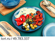 Greek appetizer of sun-dried tomatoes, black and green olives and stuffed cheese with marinated red peppers.. Tasty antipasto mix. Стоковое фото, агентство Ingram Publishing / Фотобанк Лори