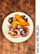 Delicious grilled octopus dish, roasted octopus tentacles sweet potatoes wedges.. Grilled octopus with potato. Стоковое фото, агентство Ingram Publishing / Фотобанк Лори