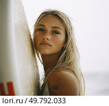 A woman with blonde hair is posing for a picture with a surfboard. Стоковое AI-изображение, AI-художник Ярославский Максим / Фотобанк Лори