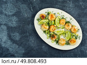 A plated dish of sea scallops garnished with fresh lime and drizzled with basil sauce. Space for text.. Fried scallops with sauce. Стоковое фото, агентство Ingram Publishing / Фотобанк Лори