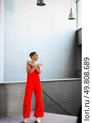 A stylish and fashionable young woman poses confidently in a strikingly beautiful red outfit, truly embodying modern elegance within a chic and vibrant space that radiates sophistication and grace. A confident young woman poses in a vibrant red outfit, showcasing her strength and beauty. Стоковое фото, агентство Ingram Publishing / Фотобанк Лори