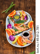 Raw fish and seafood prepared with orange and spices, perfect for cooking on wooden rustic background.. The concept of cooking, marinating fish. Стоковое фото, агентство Ingram Publishing / Фотобанк Лори