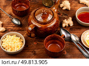 Fall immune system booster - ginger and lemon tea and ingredients on wooden rustic background.. Ginger root infusion. Стоковое фото, агентство Ingram Publishing / Фотобанк Лори