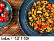 Steamed mussels with herbs and vegetables on wooden rustic background.. Fried mussels without shell with vegetables. Стоковое фото, агентство Ingram Publishing / Фотобанк Лори