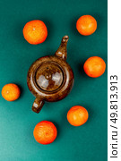 Modern style tea pot with tangerines tea and ripe fruits on wooden rustic background.. Tangerine tea in a glass teakettle. Стоковое фото, агентство Ingram Publishing / Фотобанк Лори