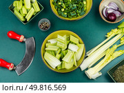 Bunch of fresh celery stalk with leaves. Food photography. Flat lay. Cut celery sticks and leaves on table. Стоковое фото, агентство Ingram Publishing / Фотобанк Лори