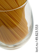 Detail of pile of uncooked spaghetti on a glass on a white background. Стоковое фото, агентство Ingram Publishing / Фотобанк Лори