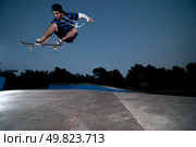 Skateboarder on a ollie at night at the local skatepark. Стоковое фото, агентство Ingram Publishing / Фотобанк Лори