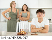 Upset guy dont speaking after discord with mother and wife standing behind. Стоковое фото, фотограф Яков Филимонов / Фотобанк Лори