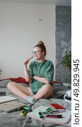 Young woman sitting on cozy bed surrounded by notebooks and markers, thoughtfully planning her day and enjoying peaceful study moment in comfortable home atmosphere. Стоковое видео, видеограф Енваев Андрей / Фотобанк Лори