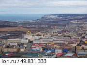 Город Магадан, Магаданская область, Дальний Восток России. Вид сверху на большой северный город. Среди зданий возвышается высокий кафедральный собор. Вдали морское побережье и бухта. Стоковое фото, фотограф Андрей Степанов / Фотобанк Лори