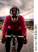 Cyclist on road bike through a asphalt road in the mountains and blue sky with clouds. Стоковое фото, агентство Ingram Publishing / Фотобанк Лори