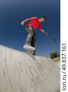 Skateboarder doing a BS feeble grind on a curb. Стоковое фото, агентство Ingram Publishing / Фотобанк Лори