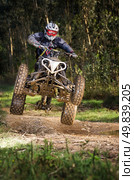 Quad rider jumping on a forest trail. Стоковое фото, агентство Ingram Publishing / Фотобанк Лори