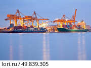 Big Container Cargo freight ship with working crane in shipyard at dusk for Logistic Import Export background. Стоковое фото, агентство Ingram Publishing / Фотобанк Лори