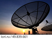 black antenna communication satellite dish over sunset sky in cityscape. Стоковое фото, агентство Ingram Publishing / Фотобанк Лори