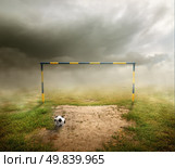 Football field, football goal, deflated ball and cloudy sky. Стоковое фото, агентство Ingram Publishing / Фотобанк Лори