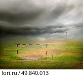 Football field, football goal, deflated ball and cloudy sky. Стоковое фото, агентство Ingram Publishing / Фотобанк Лори