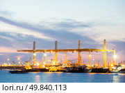 Container stacks and crane in shipyard at dusk for cargo Goods and Logistic background. Стоковое фото, агентство Ingram Publishing / Фотобанк Лори