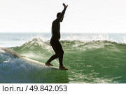 Long boarder surfing the waves at sunset in Portugal. Стоковое фото, агентство Ingram Publishing / Фотобанк Лори