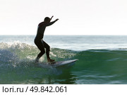 Long boarder surfing the waves at sunset in Portugal. Стоковое фото, агентство Ingram Publishing / Фотобанк Лори
