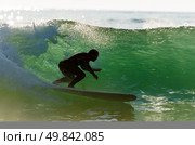 Long boarder surfing the waves at sunset in Portugal. Стоковое фото, агентство Ingram Publishing / Фотобанк Лори