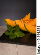 Juicy honeydew melon on a black slate tray. Стоковое фото, агентство Ingram Publishing / Фотобанк Лори
