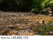 Люди выкладывают пирамидки из камней на тропе к водопадам Руфабго (2024 год). Редакционное фото, фотограф Татьяна Новикова / Фотобанк Лори