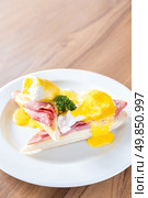 Eggs Benedict breakfast- toasted English muffins, ham, poached eggs, with buttery hollandaise sauce. Стоковое фото, агентство Ingram Publishing / Фотобанк Лори