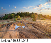 Puddle on a country road to mountain forest. Стоковое фото, агентство Ingram Publishing / Фотобанк Лори