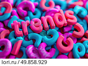 A vibrant pile of plastic letters forming the word trends in various colors on a white background. Стоковое AI-изображение, AI-художник Данила Большаков / Фотобанк Лори