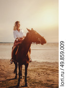 Riding Into the Sunset Gallops a Woman in Simple Dress. Стоковое фото, фотограф Aleksandr Golubev / Фотобанк Лори