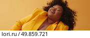 Overweight woman wearing a vibrant yellow jacket with her eyes closed, expressing a moment of introspection and relaxation. Стоковое AI-изображение, AI-художник Данила Большаков / Фотобанк Лори