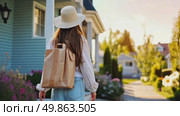 A woman strolls happily home through her sunny suburban neighborhood, carrying a bag with essentials or groceries. Стоковое AI-видео, аниматор Данила Большаков / Фотобанк Лори